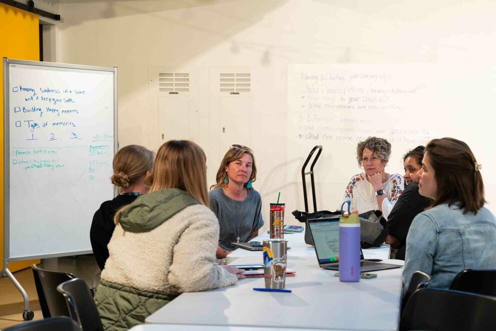 A group of adults sit around a table.
