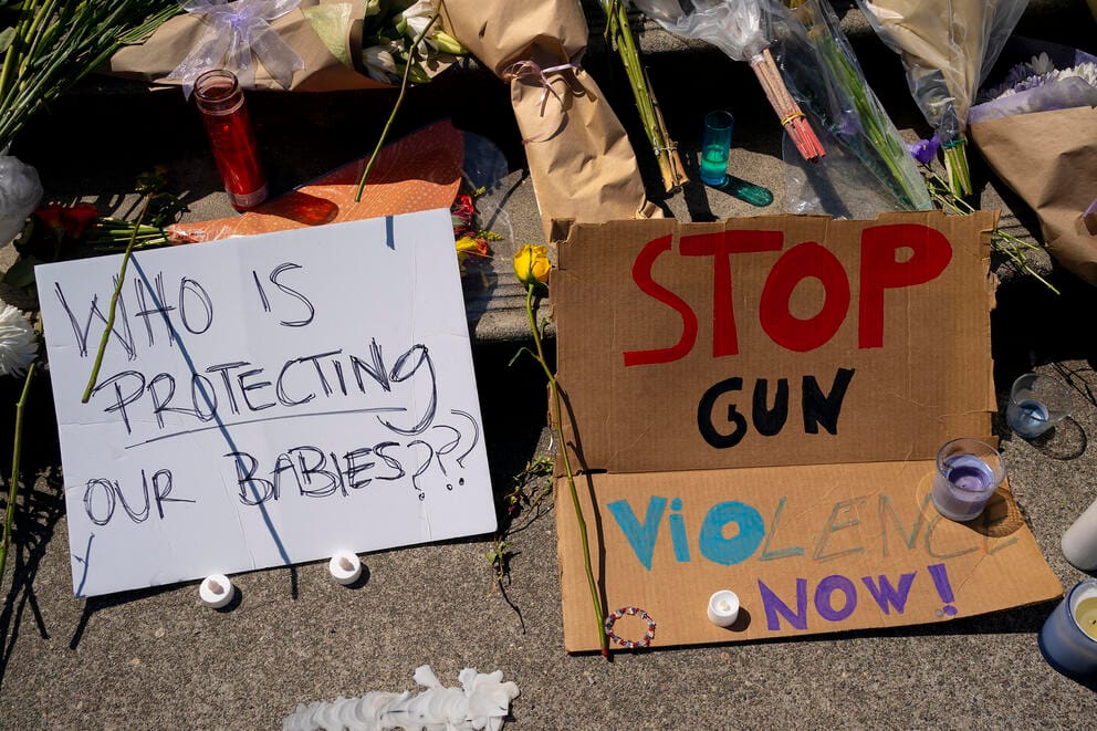 Signs, flowers, and other items are seen at a memorial for Amarr Murphy-Paine