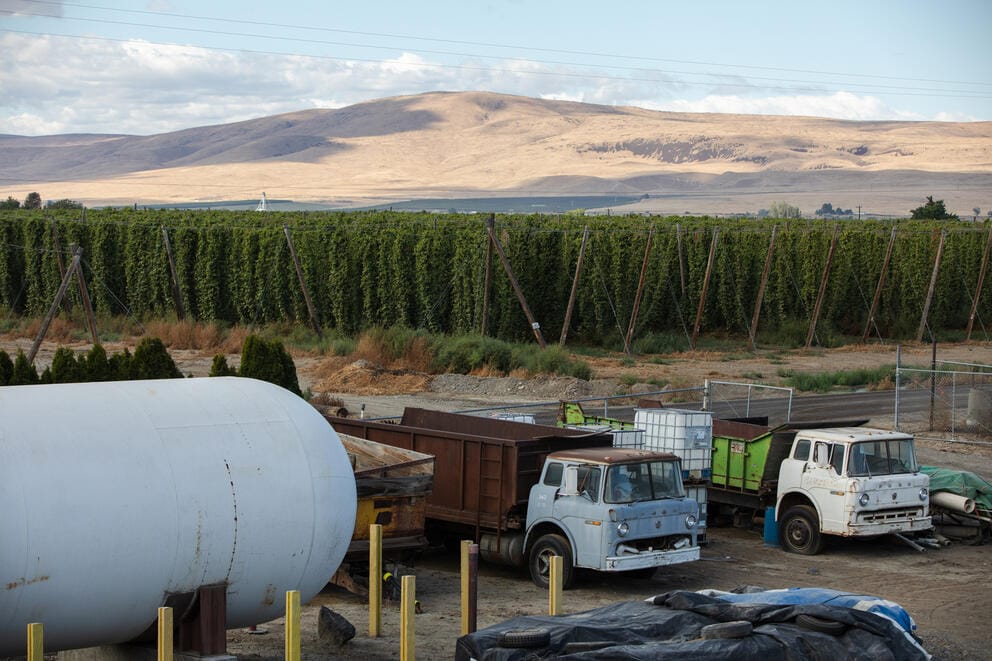 A view from above of hop fields and the hillsides of Wapato, some large tanks and trucks are parked in the foregroundand 