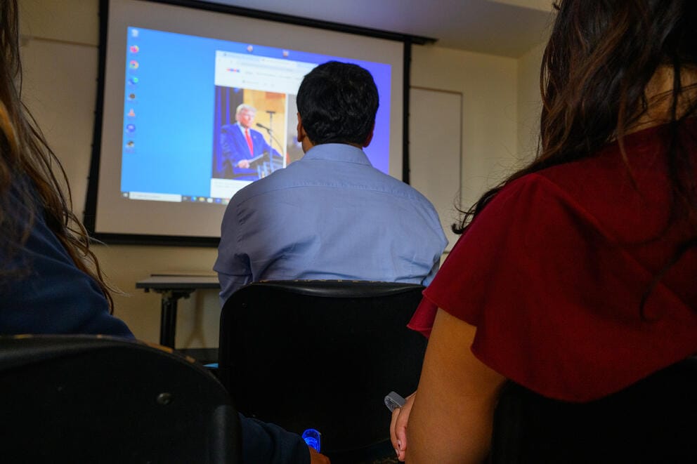 person sitting in front of a tv screen while demostrating the ring