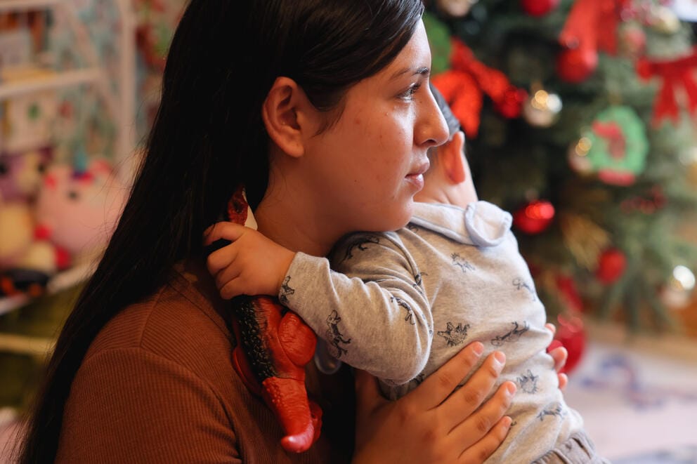 a woman holds a toddler in her arms