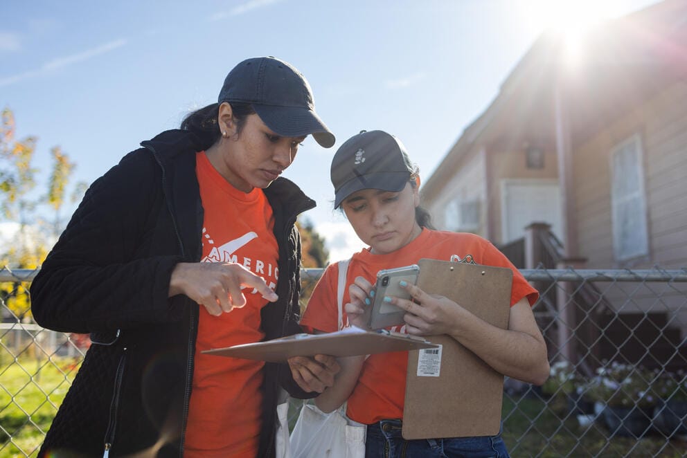 Volunteers look at list of houses to visit 