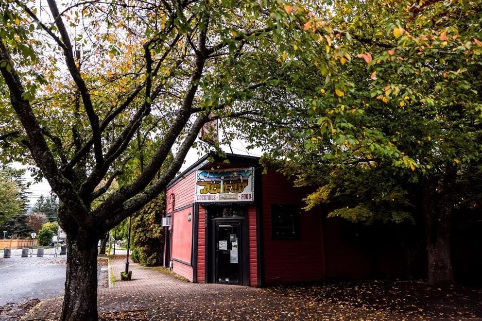 A building near a tree with a sign outside that says 